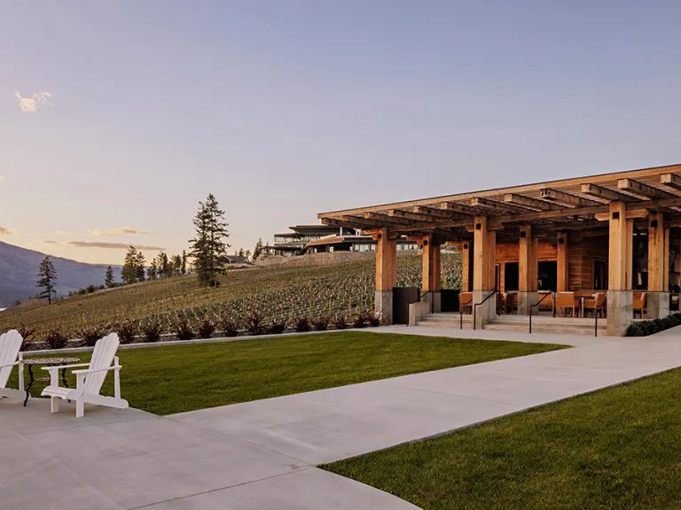 O'Rourke Family Estate's wood-and-stone pergola-style building overlooks a vineyard hillside at dusk.