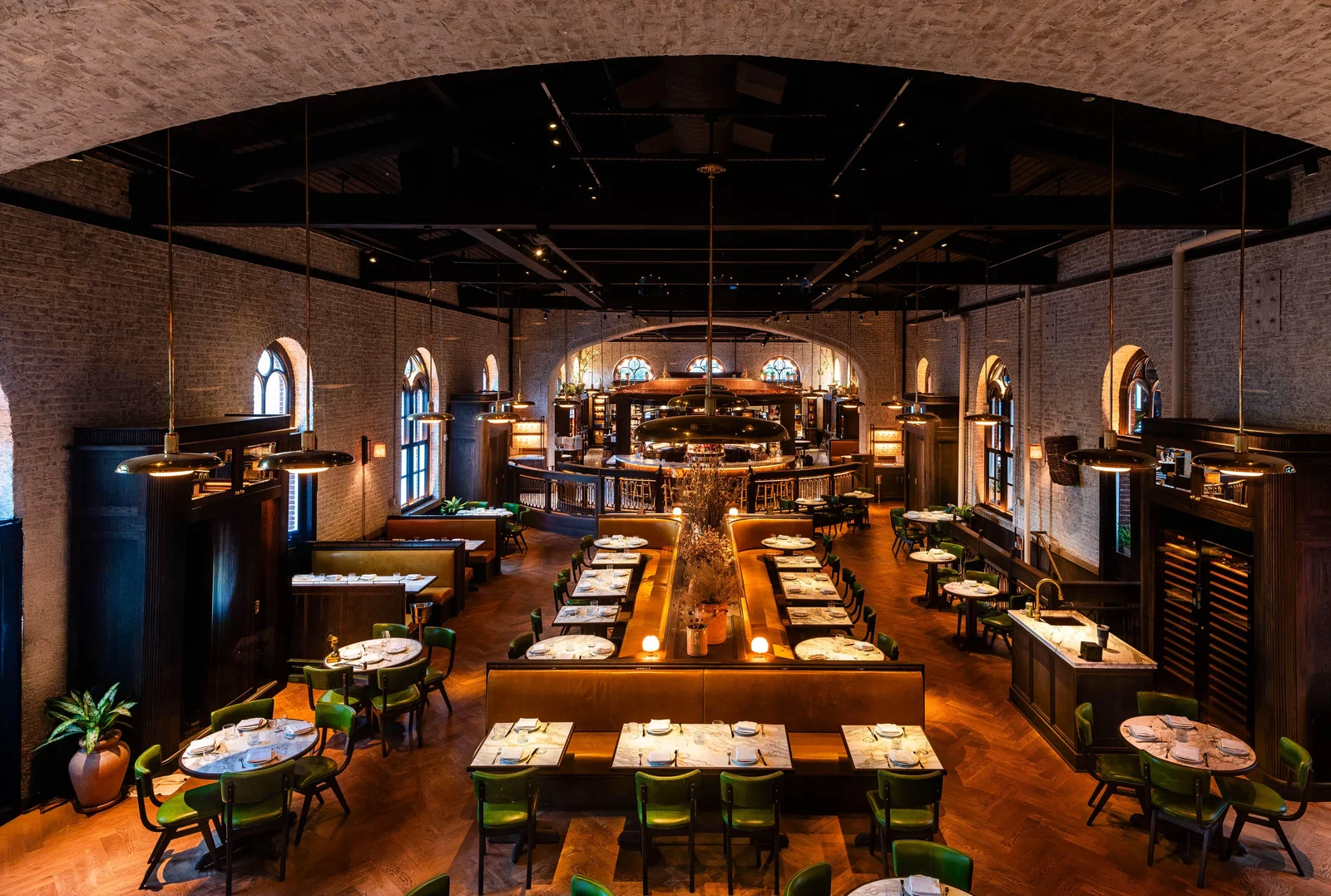 The Osteria Mozza Experience showcases vibrant green chairs complementing the warm wooden tones.