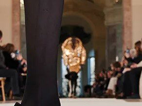 Paris Fashion Week: A model in black tights and heels walks the runway at a haute couture show.