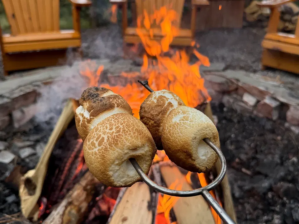 Three toasted marshmallows held over a campfire at Paws Up