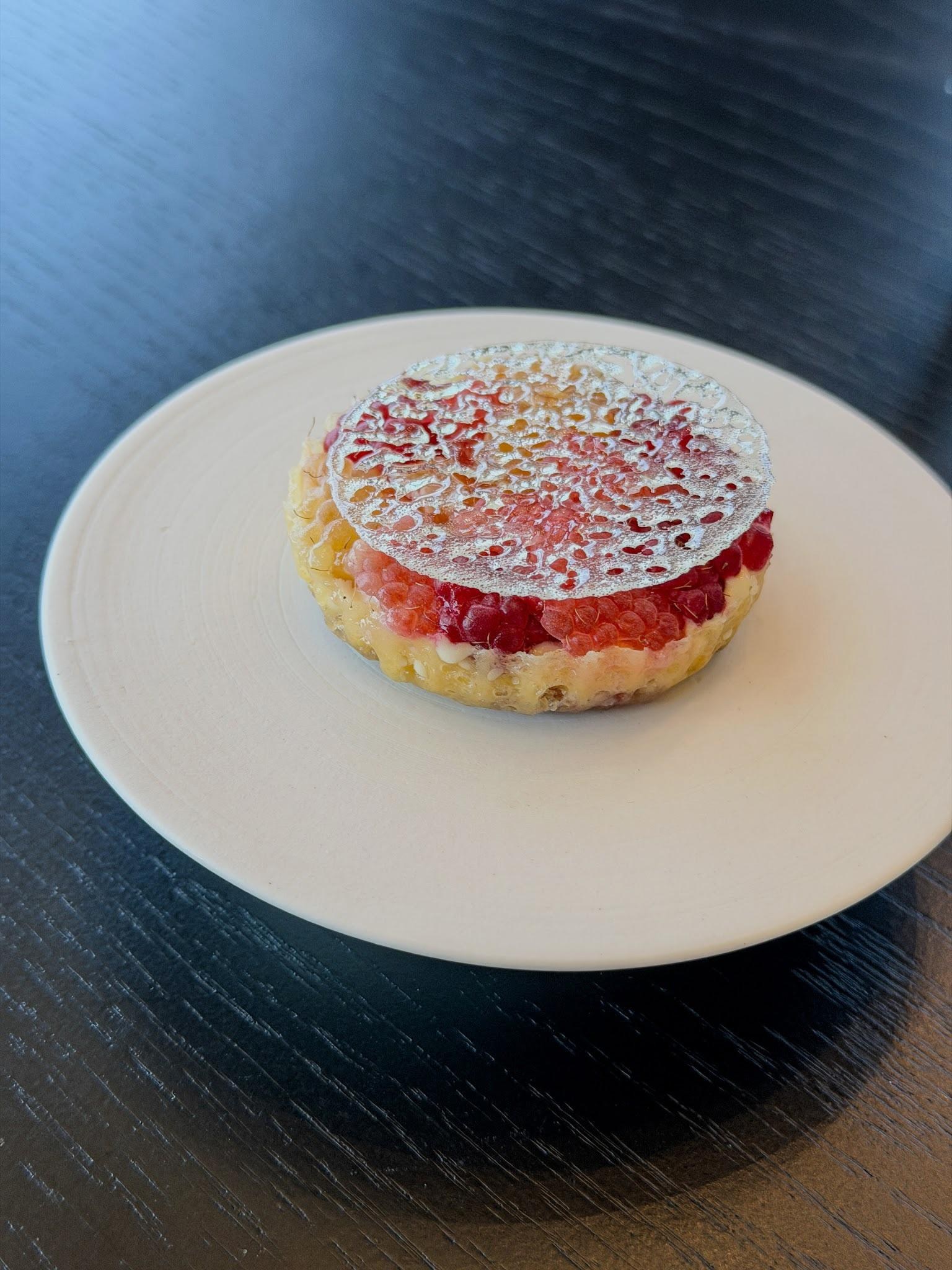 A plated dessert featuring a raspberry mosaic tart with a caramelized sugar top, photographed in editorial style; the source page (Eater Portland) exp
