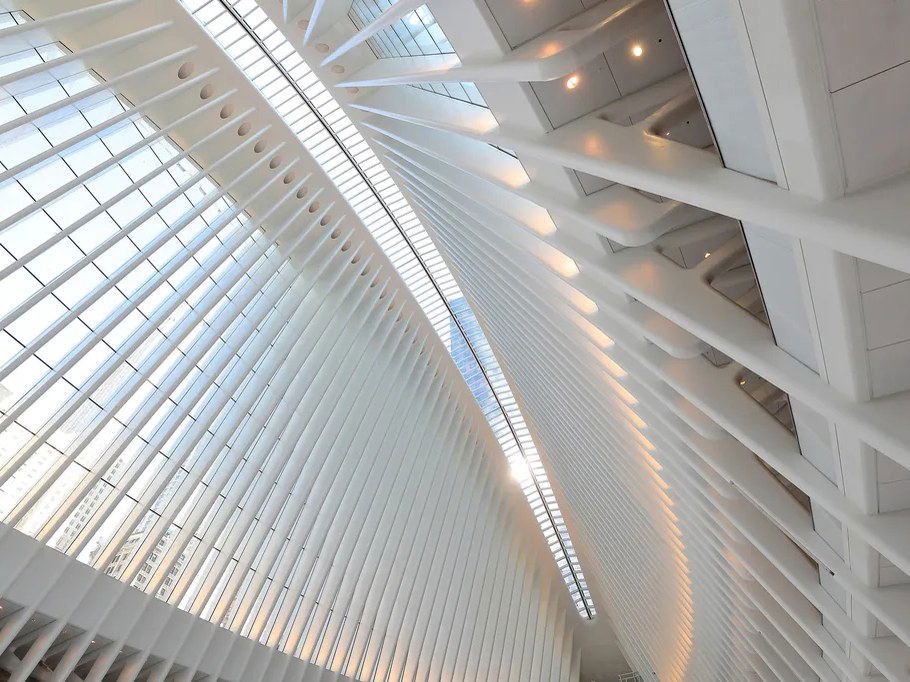 The interior of the Oculus at World Trade Center features soaring white ribs and a central skylight, creating a bright, architectural space.