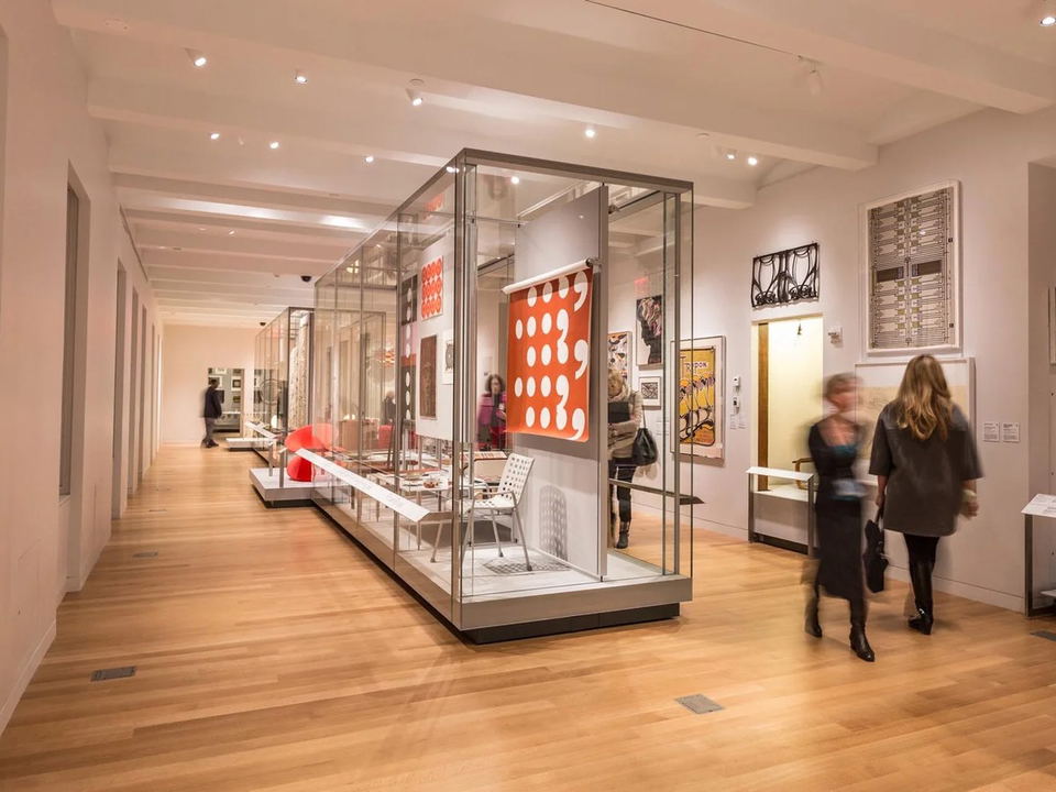 Interior of a design museum with glass display cases and artwork.