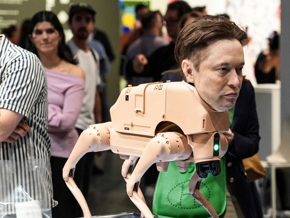 A robot dog with a human face on its head is displayed on a platform, surrounded by people at an art exhibition.