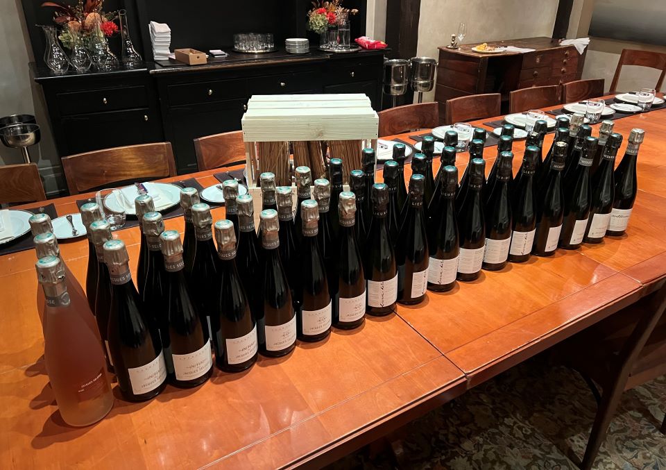 Jacques Selosse bottles line a formal dining table, ready for a retrospective tasting.