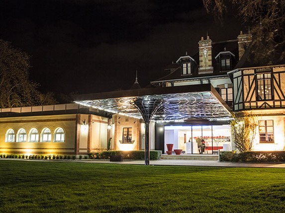 Domaine Les Crayères, a concierge route for Krug, illuminated at night.