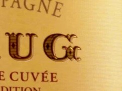 A close-up of a Krug Grande Cuvée 169ème Édition Brut champagne bottle, with its yellow label clearly visible.
