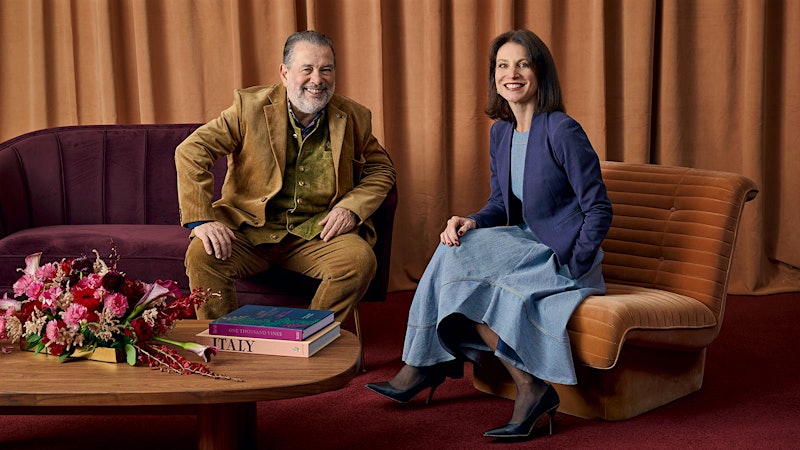 Professional portrait of two people seated on sofas in an editorial setting; source page explicitly attests this is Michel Chapoutier (winemaker).
