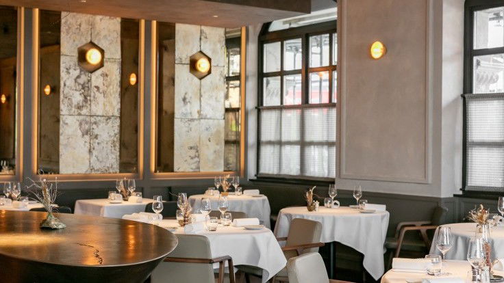 Dining area with tables, chairs, and wall mirrors in The Ledbury.