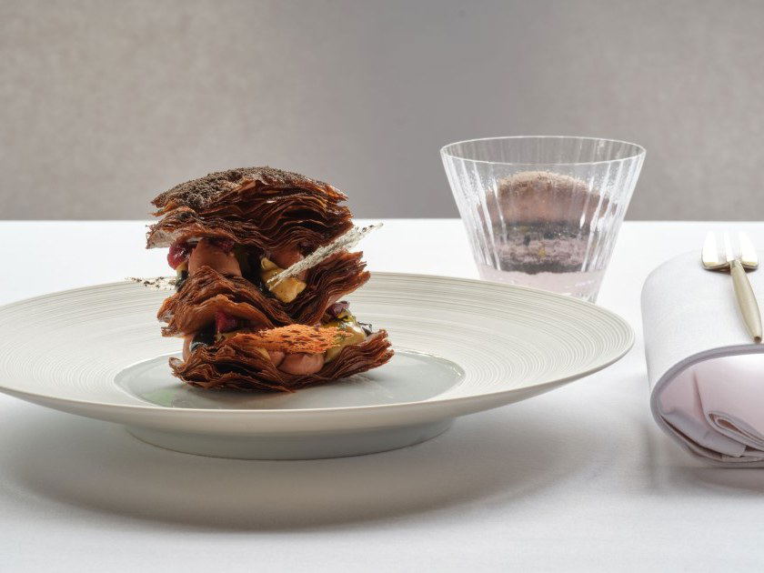 The Ledbury: An intricate, layered pastry dish with a drink and elegant place setting.