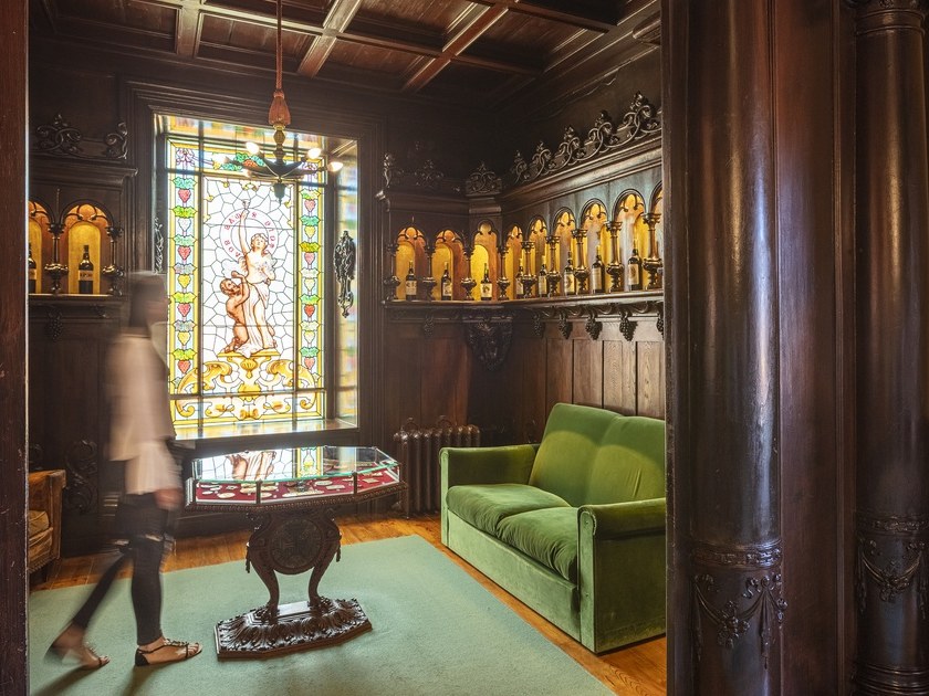 Ramos Pinto Lodge: A visitor walks through the ornate, wood-paneled room with a vibrant stained-glass window.