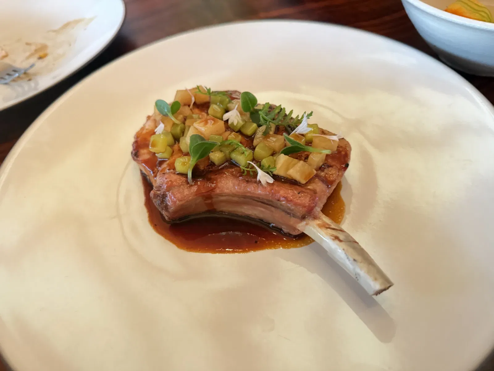 Bone-in dry-aged Kurobuta pork with vegetables and charred pickle jus at PRESS