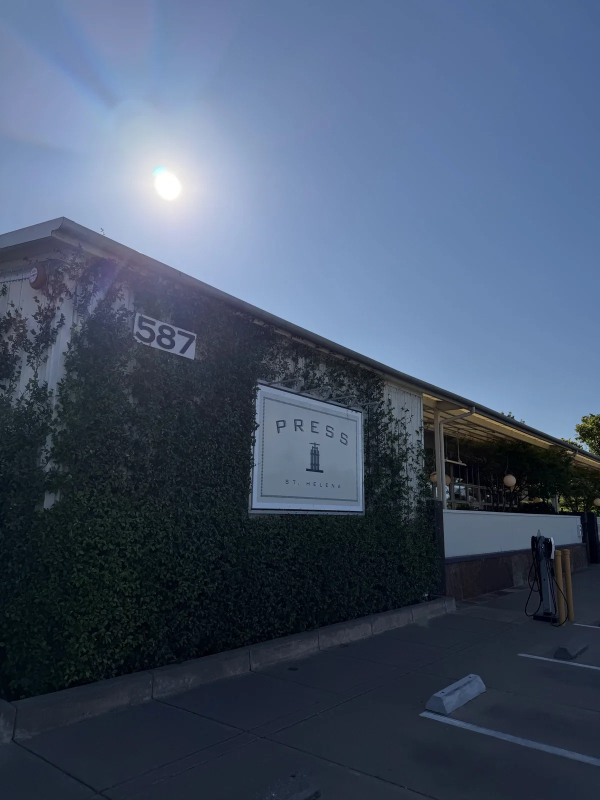 Ivy-covered exterior and PRESS sign at 587 St Helena Highway