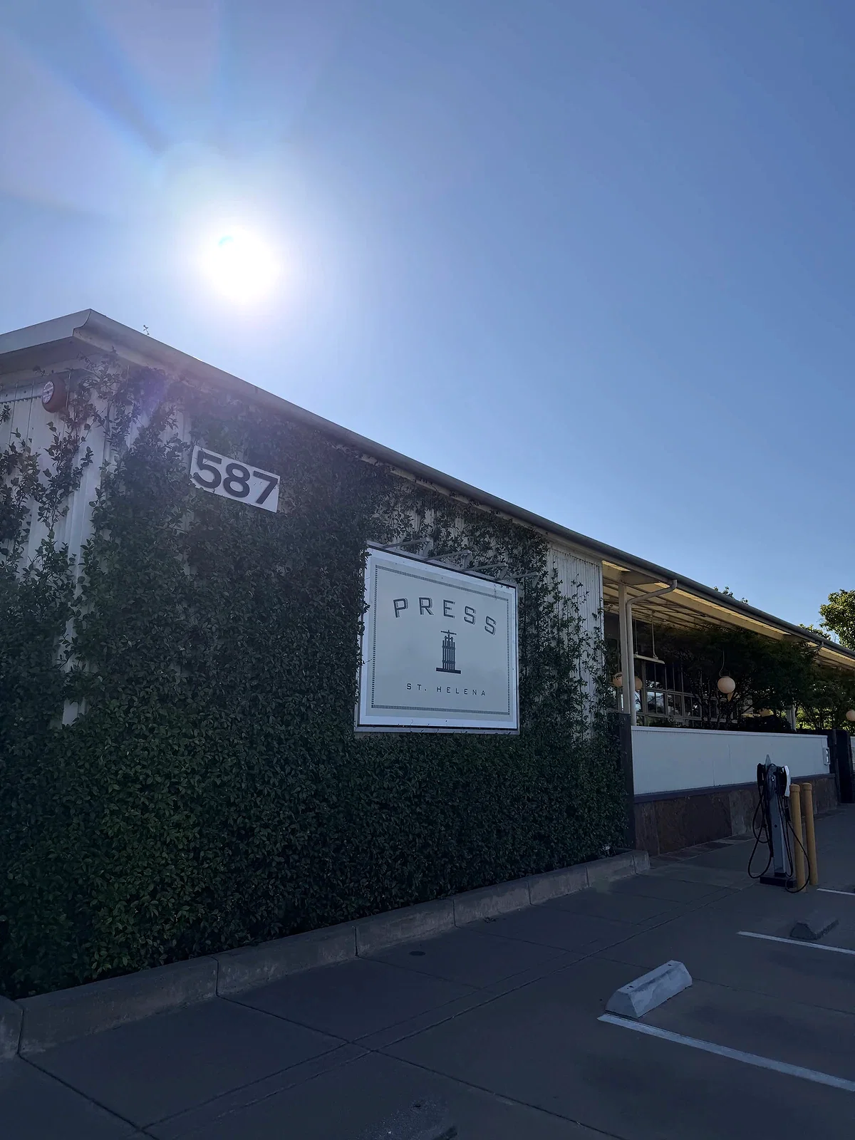 Ivy-covered exterior and PRESS sign at 587 St Helena Highway