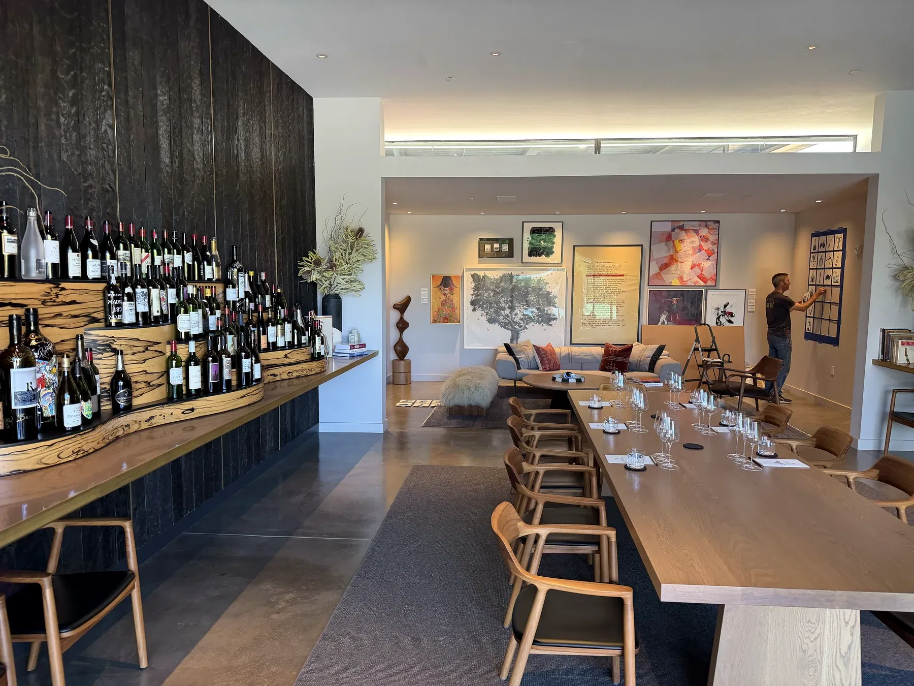 Long tasting table surrounded by contemporary art and rare bottles at Realm Houyi Estate