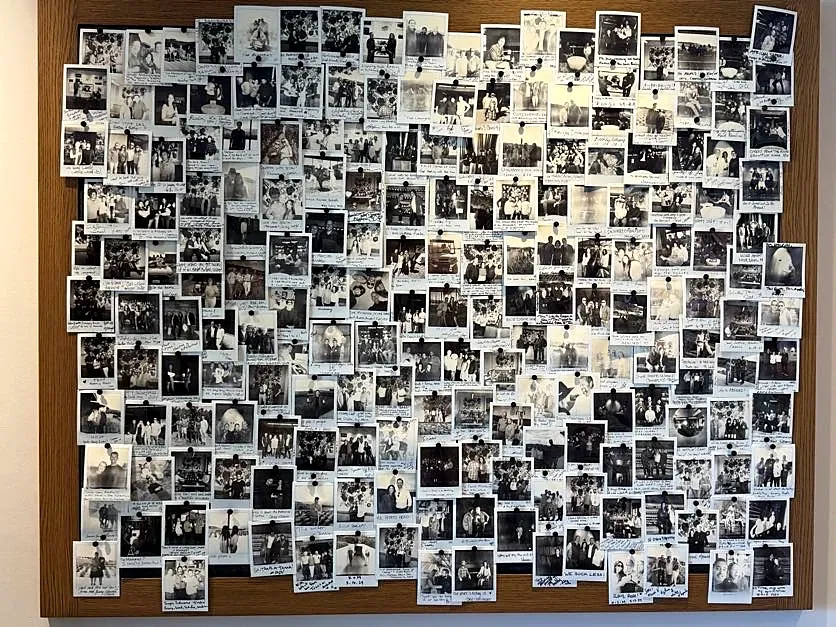 Wall filled with guest Polaroids and handwritten notes at Realm Houyi Estate