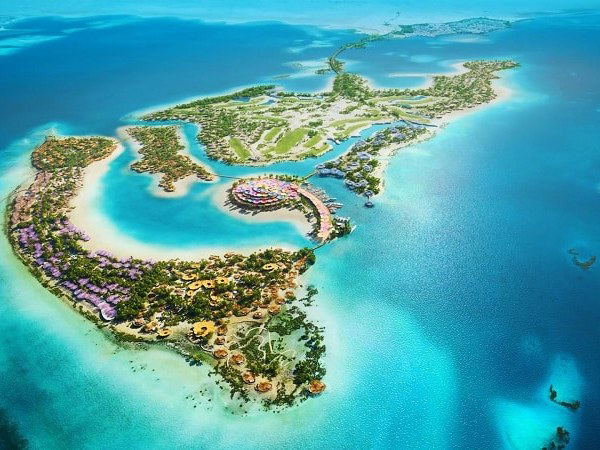 Aerial view of a luxury resort development on an island with distinctive curved pavilions, lagoons, and coastal integration; source page explicitly na.