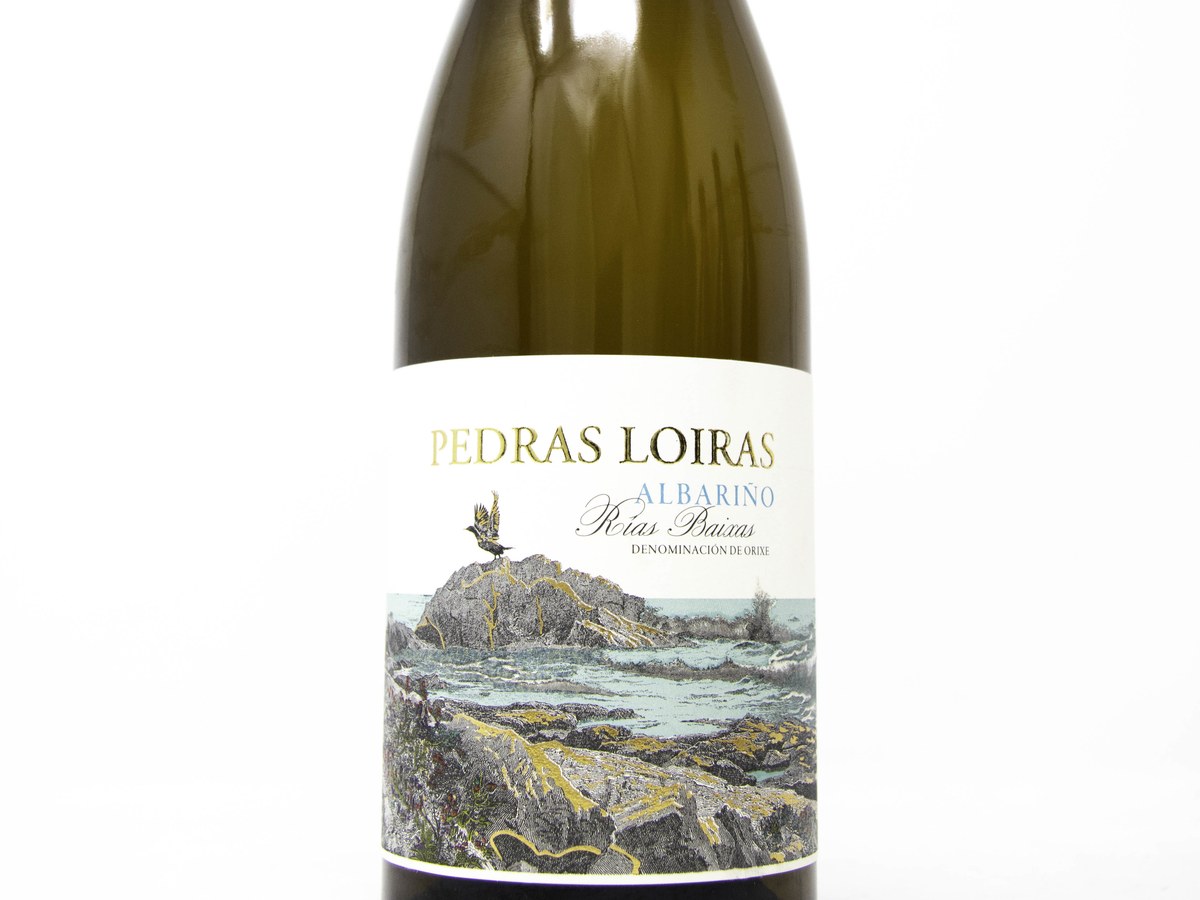 A bottle of Pedras Loiras Albariño Rías Baixas wine, featuring a label with an illustration of a bird on a rocky coastline with ocean waves.
