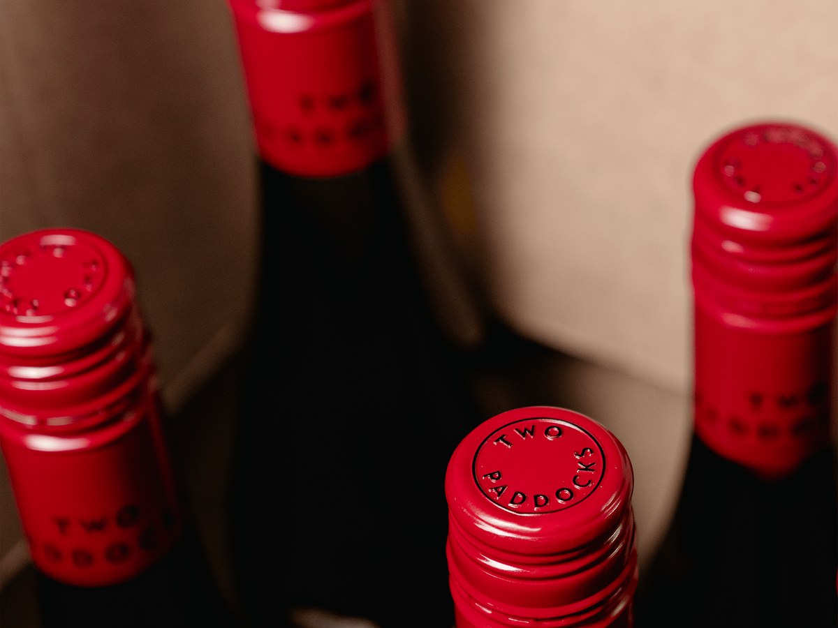 Sam Neill's Two Paddocks wine bottles in a case.