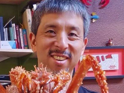 Hajime Sato proudly presents a king crab, embodying his commitment to sustainable sourcing.