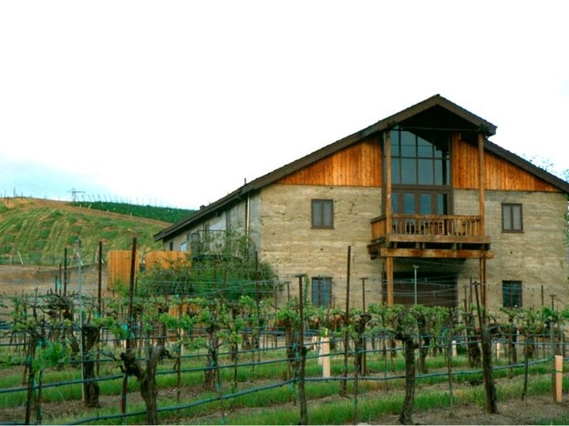 Shanti Winery's Home Ranch features a stone and wood winery building amidst vineyard rows and hillside vineyards.