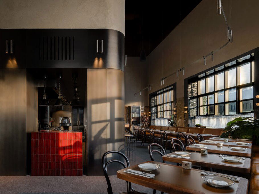 Window (Alserkal Avenue) offers a glimpse into its open kitchen and inviting dining space with long wooden tables.
