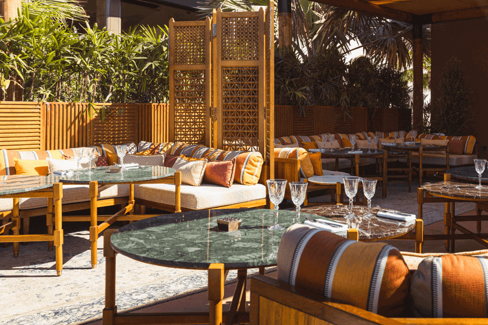 Ninive (J1 Beach), with its inviting outdoor lounge area featuring plush orange and cream striped cushions.