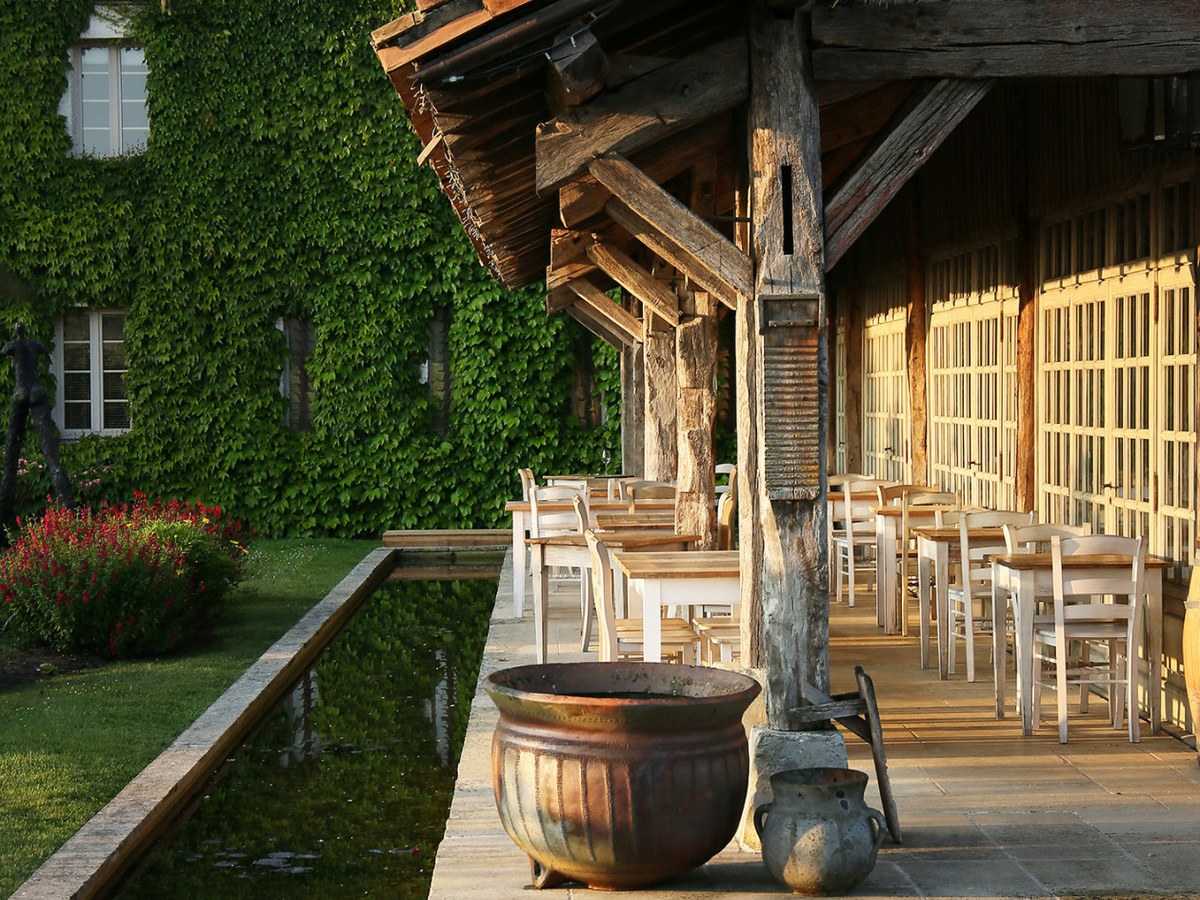 La Table du Lavoir offers a relaxed lunch setting with rustic charm and a tranquil reflecting pool.