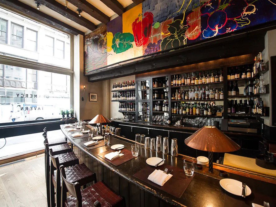 Gramercy Tavern's inviting bar, with its vibrant mural and extensive bottle collection, reflects fine dining's evolution.
