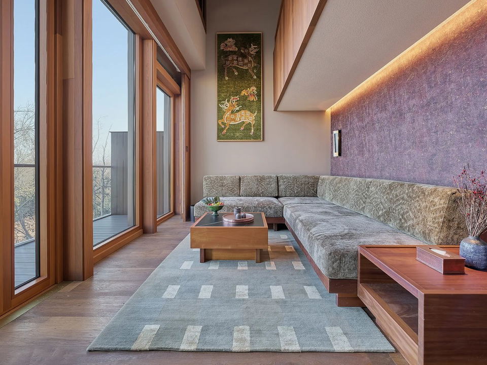 songtsam linka kunming’s living room-style seating area features a long banquette sofa and floor-to-ceiling windows.
