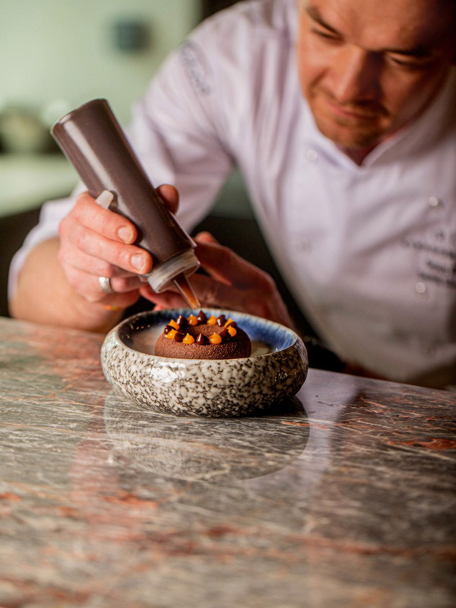 Robert Panek meticulously finishes a signature dessert at Stradomska 12.