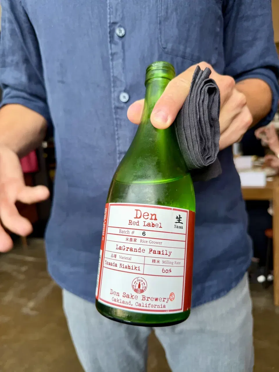 Den Sake Brewery Red Label Batch 6 bottle presented tableside
