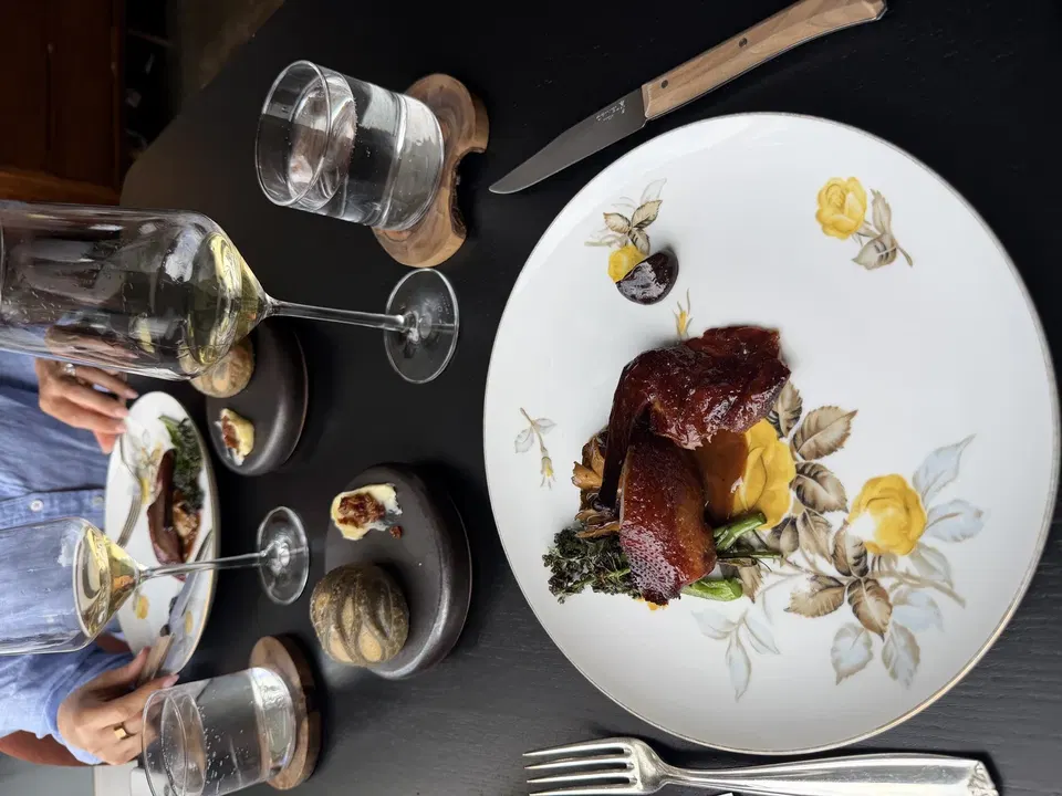 California squab with broccolini beside marbled sesame bread