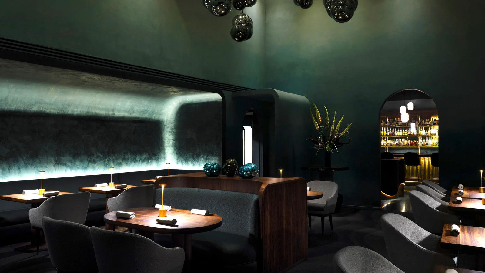 Providence restaurant's elegant dining room features deep teal walls, unique lighting, and a sophisticated bar.