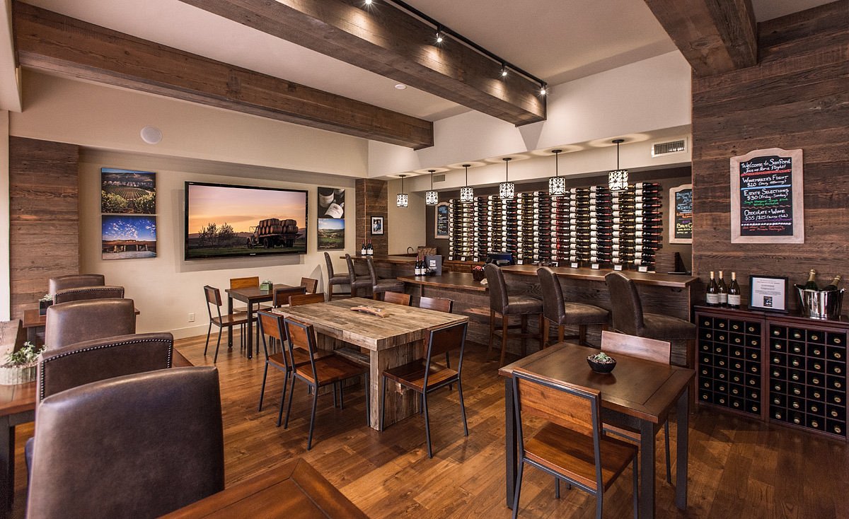 Sanford Winery showcases a vast wall display of wine bottles above its long tasting bar.