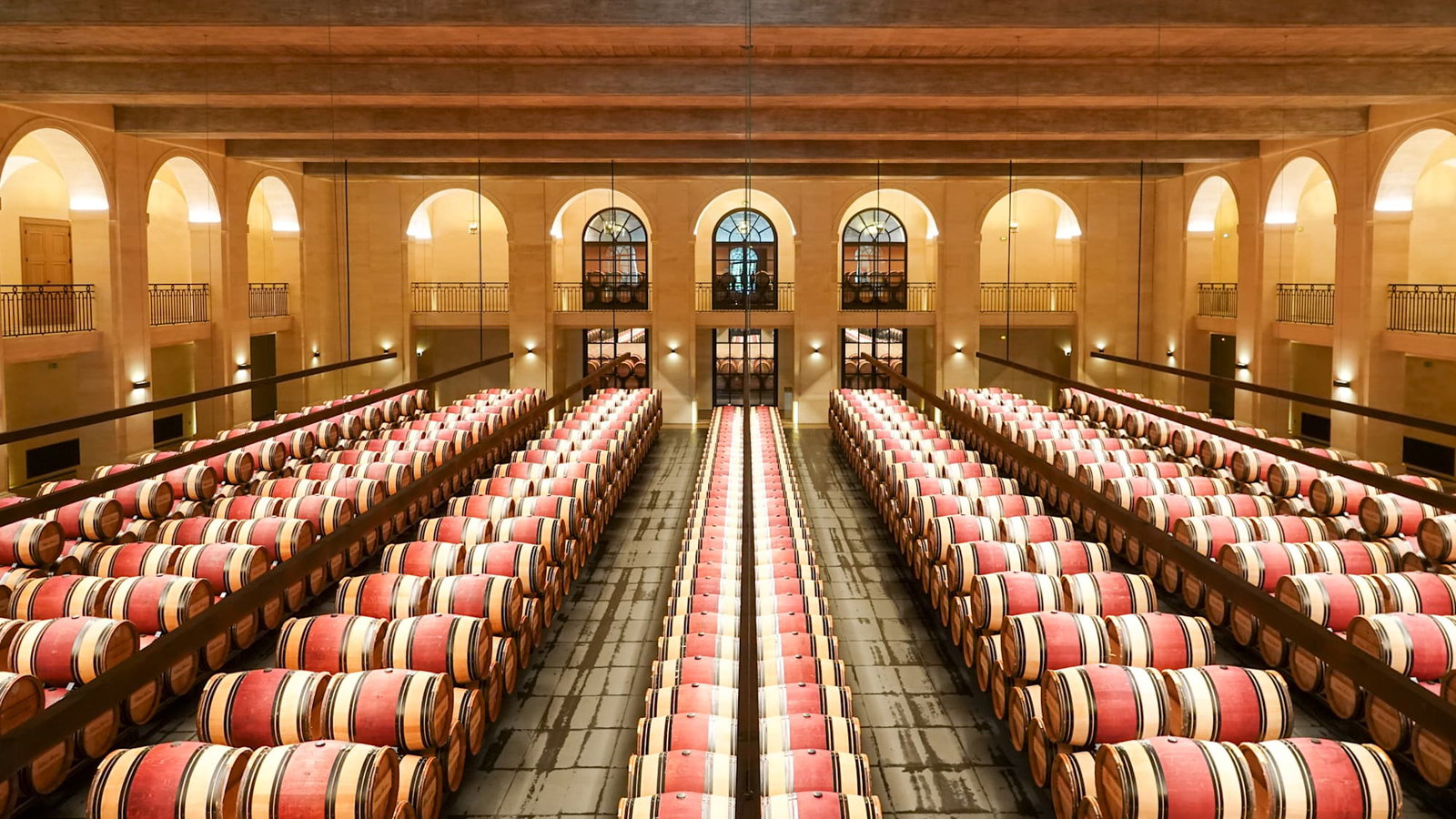 Our 2026 Château Montrose Visit Verdict: the vast cellar is filled with neatly stacked, red-banded barrels.