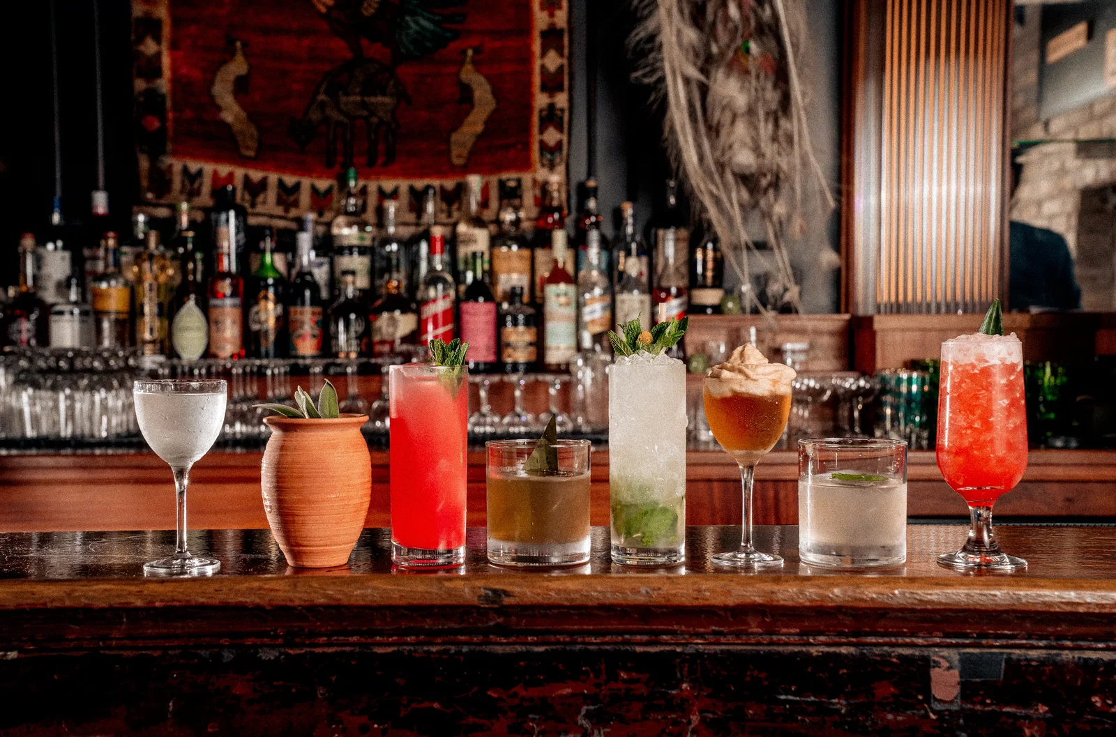 A vibrant array of cocktails on a bar counter, showcasing Los Angeles' diverse nightlife.