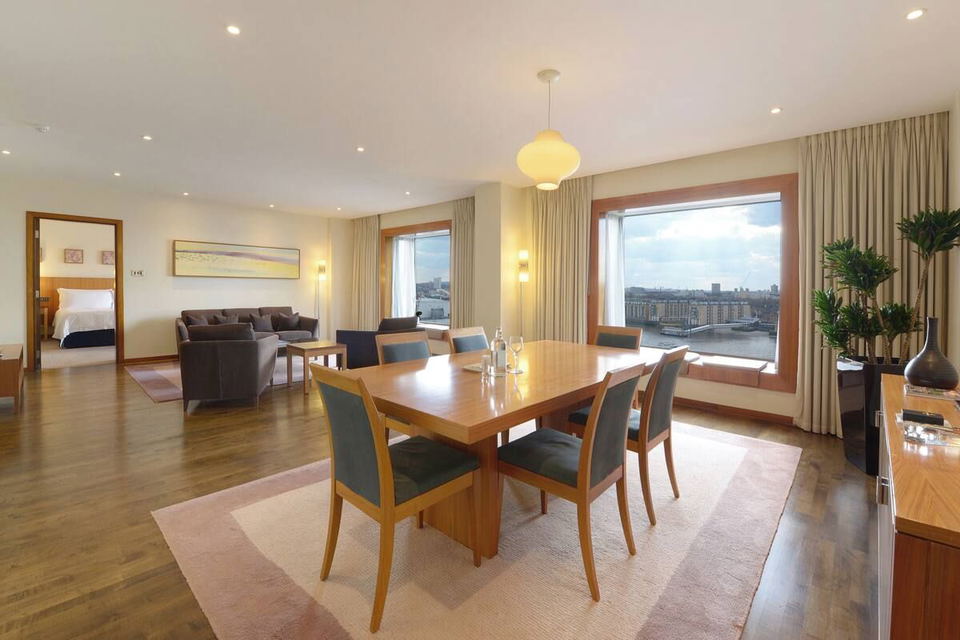 A spacious suite at Canary Riverside Plaza with a dining area, living room, and a bedroom visible through an open doorway.