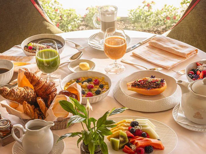 Luxury breakfast spread with fruits, pastries, and drinks.