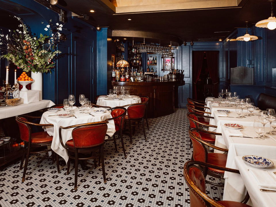 Elegant dining room with bar, set tables, and patterned floor