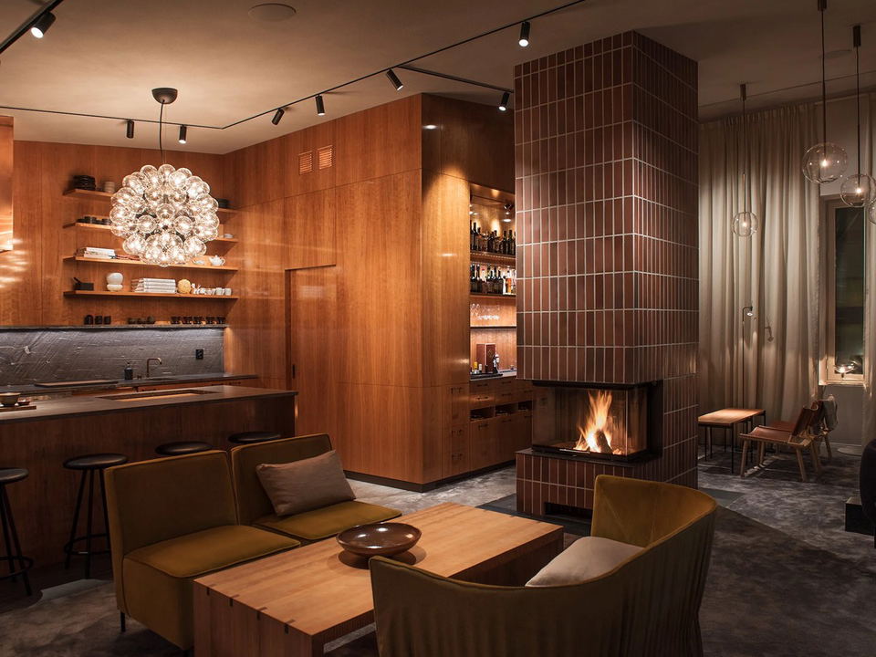 Interior lounge area with wooden cabinetry, fireplace, and modern lighting fixtures.