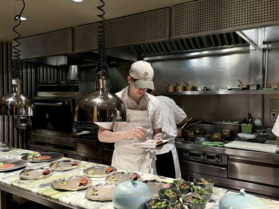 Quintonil: Chefs plate dishes on a marble counter in an open kitchen.