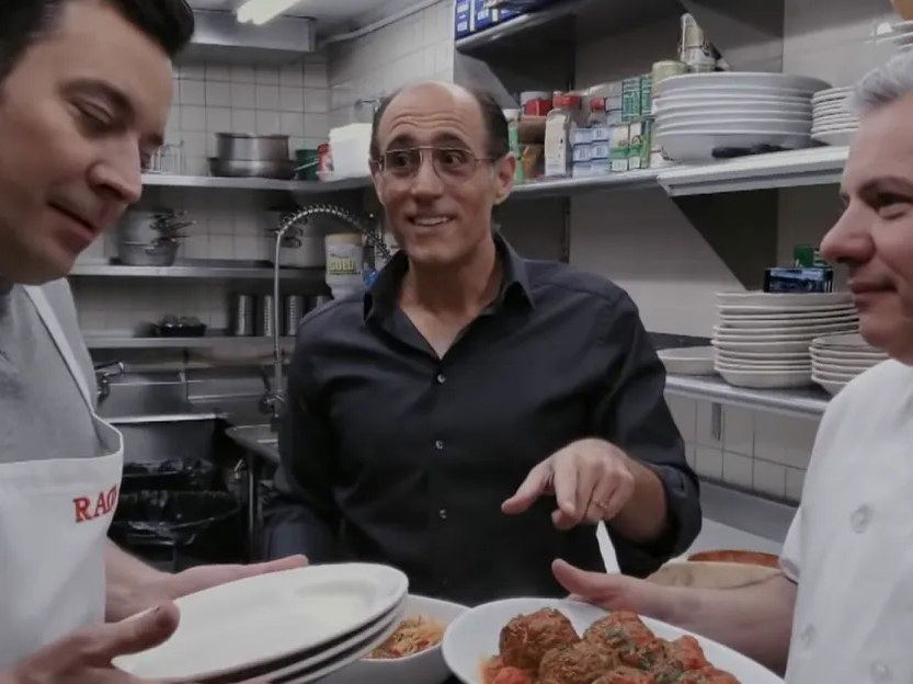 Frank Pellegrino Jr. (center) with two chefs, one holding a plate of Rao's famous meatballs.