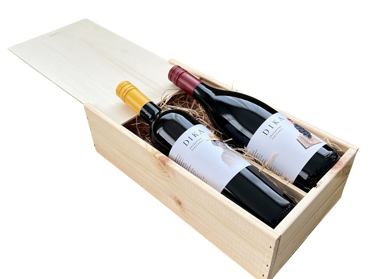 Two bottles of Dika wine by Enosophia, one Graševina with a yellow cap and one Frankovka with a red cap, nestled in straw within a wooden gift box
