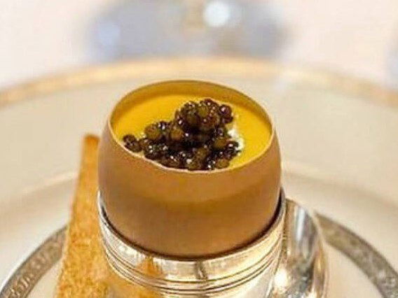 Caviar served in an egg-shaped dish with a toast on the side.