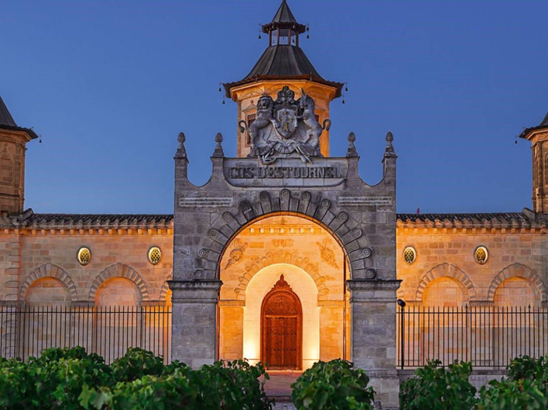 A Médoc château illuminated at dusk.
