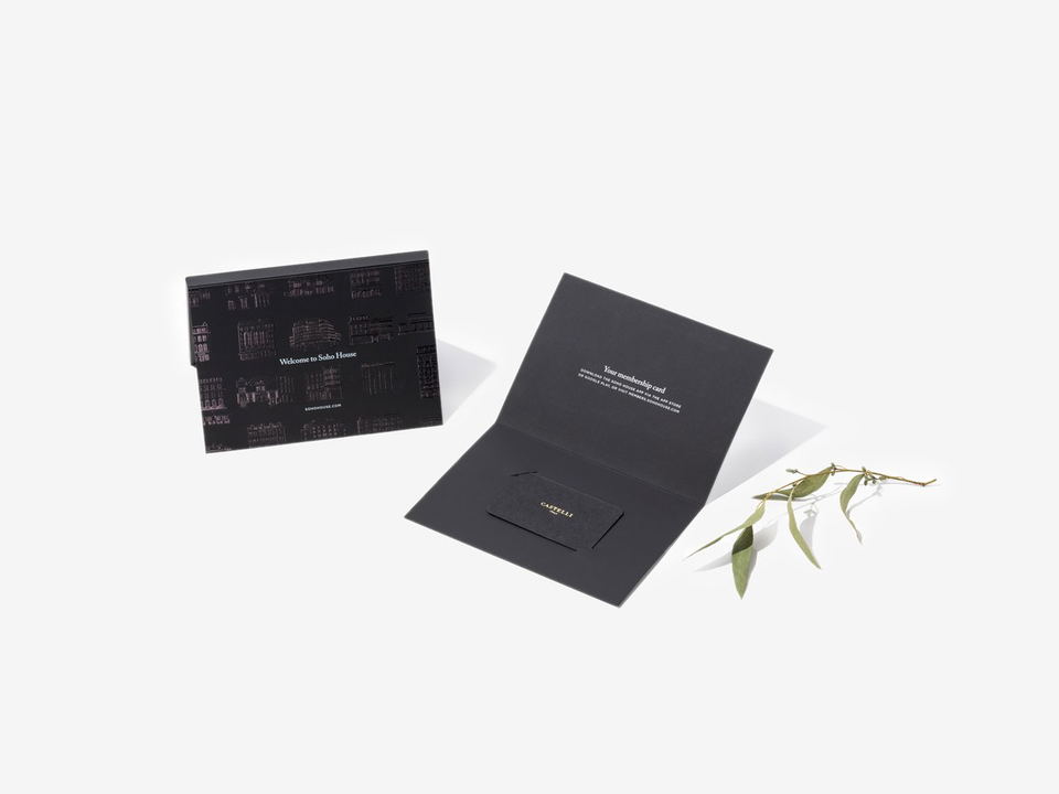 A black envelope with 'Welcome to Soho House' and architectural illustrations, an open black folder with 'Your membership card' text, and a