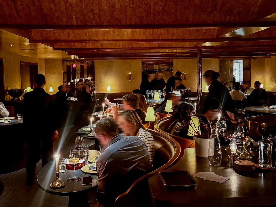 Lielle dining room with guests seated at curved counters under a warm wood ceiling.