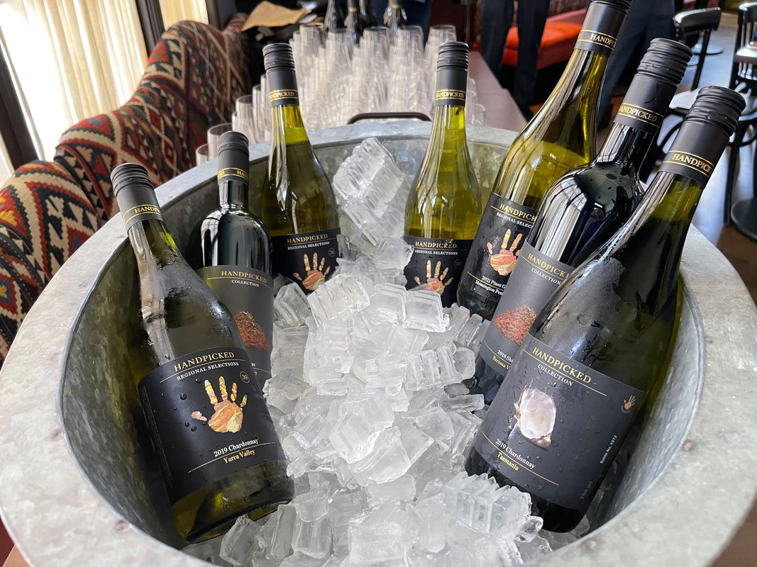 Multiple Handpicked Wines bottles packed in a galvanised ice tub, labels showing 2019 Yarra Valley Chardonnay, 2019 Tasmania Chardonnay, 2021 Mornington Peninsula Pinot Gris, and 2018 Barossa Valley Shiraz.