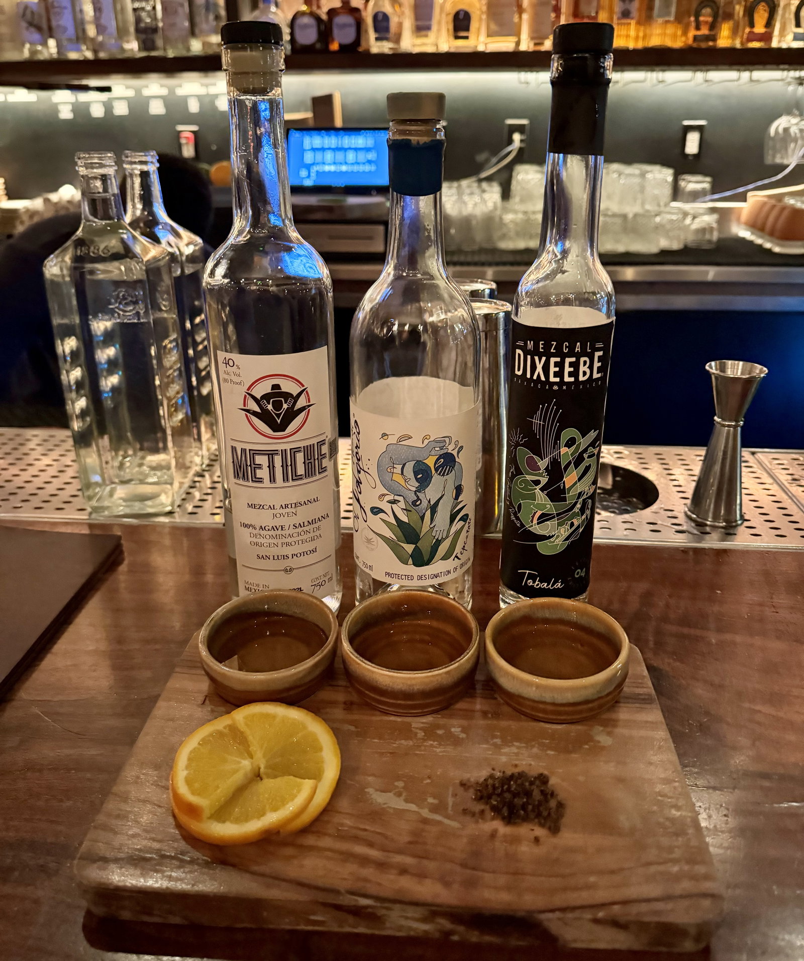 three bottles of mezcal with orange and salt